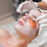 A young girl in a beauty salon in a cosmetology room lies on a bed relaxes with a mask on her face and patches under her eyes